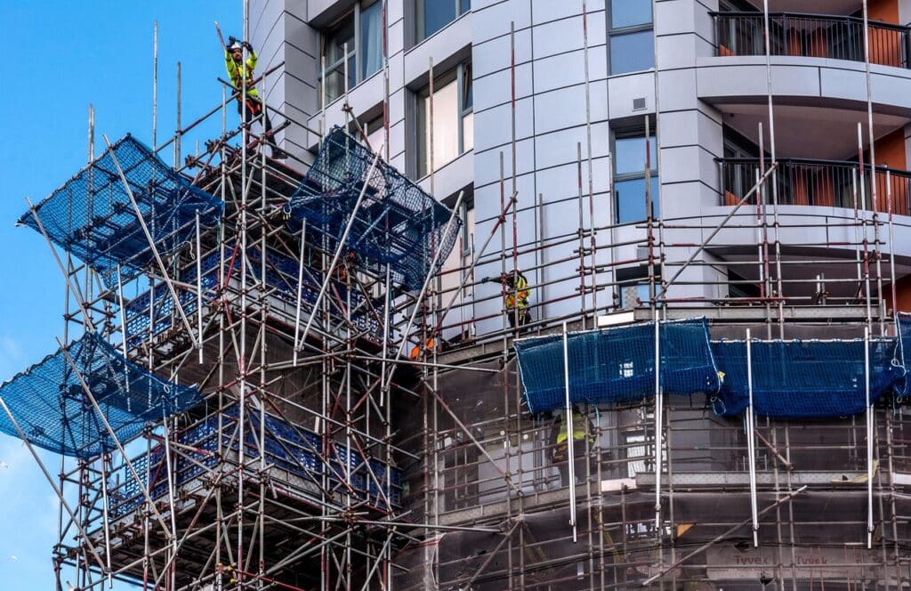 crew on scaffolding inspecting building facade
