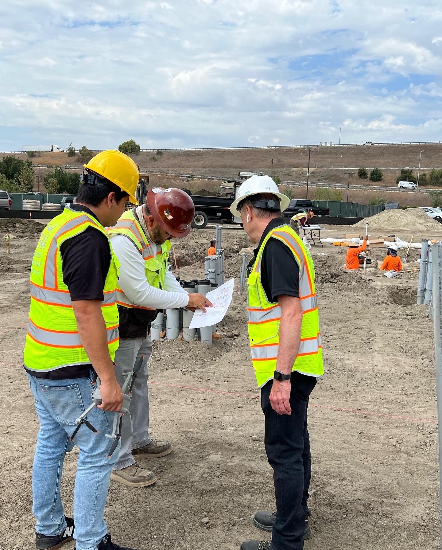 Construction Supervisor reviews site plans with drone pilots